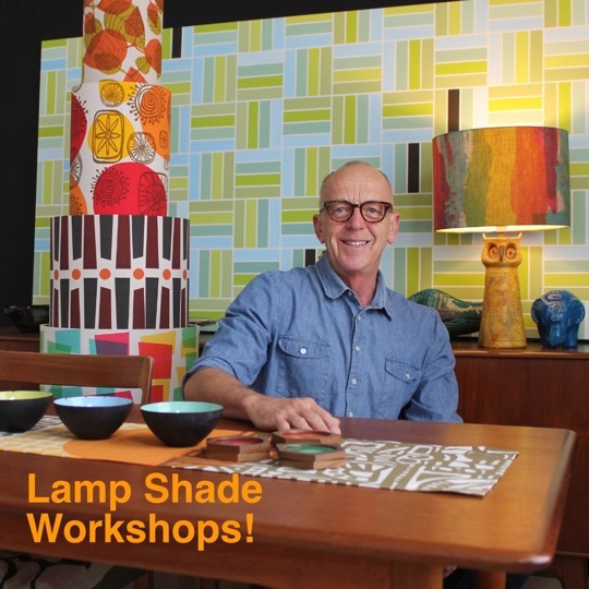 Man seated at a table surrounded by patterned lampshades